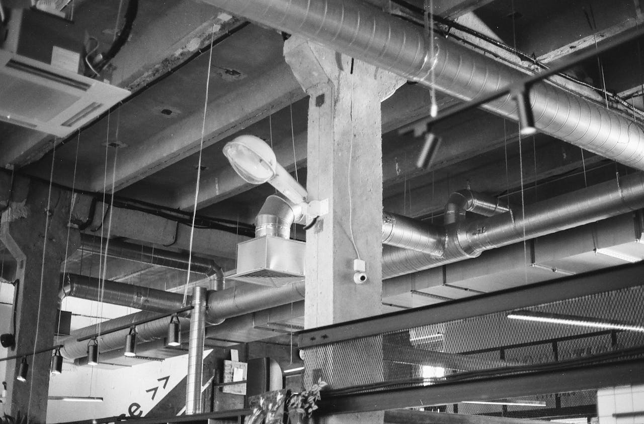 why-choose-us Black and white photo of industrial interior with exposed ducts and pipes in Saint Petersburg.