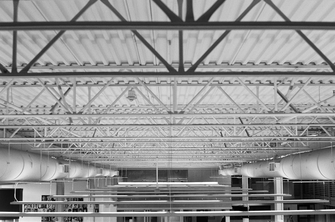 about-01 Monochrome view of an industrial ceiling with metal beams and ductwork in Vancouver.